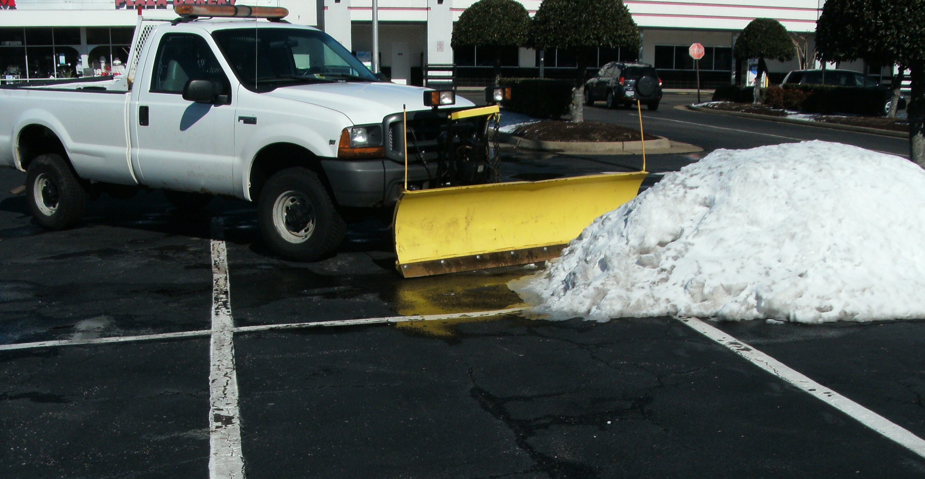 Able Snow Patrol plow truck clearing a commercial lot